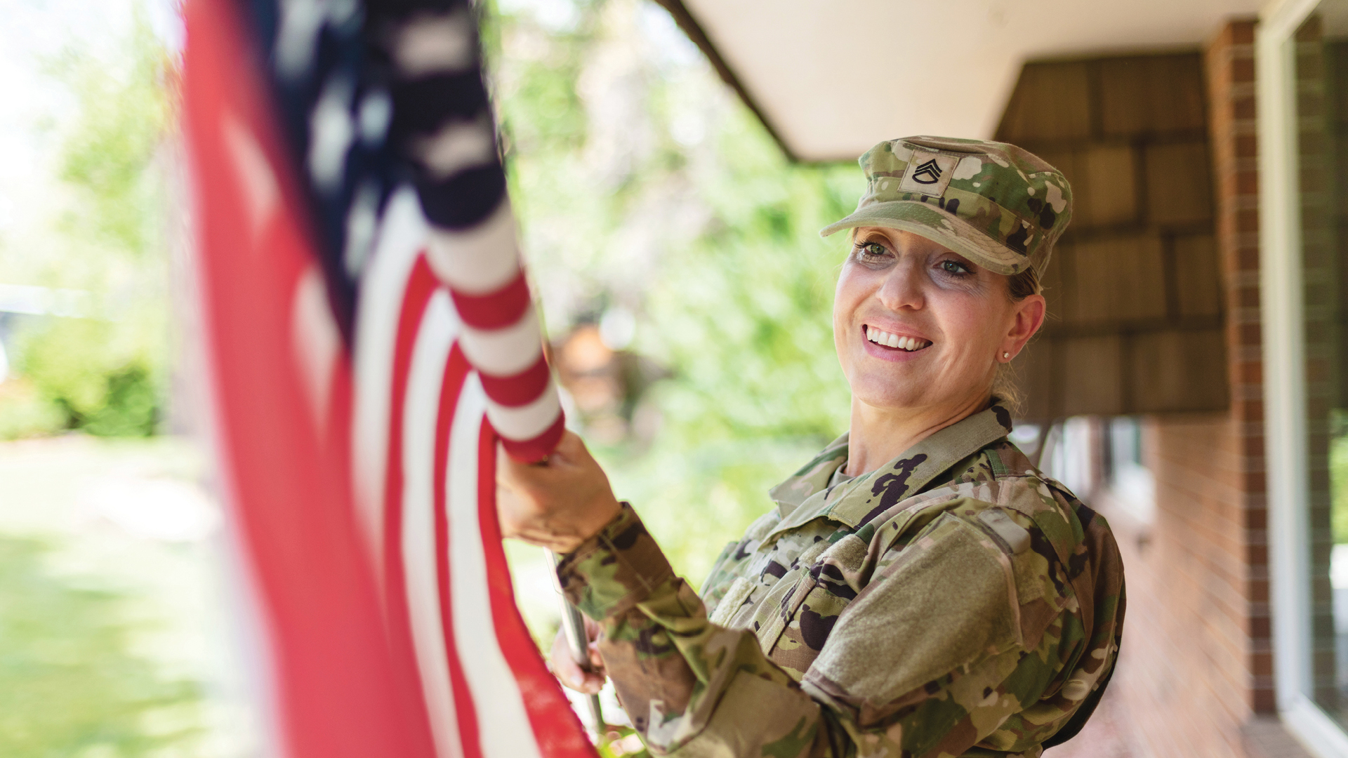 Military service member hanging American flag