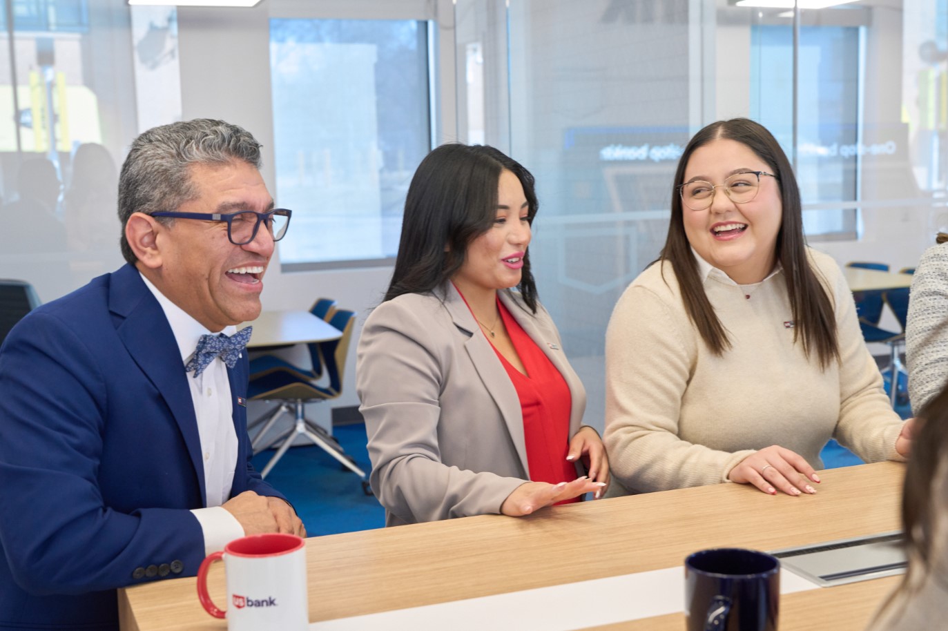 Three people at a table laughing