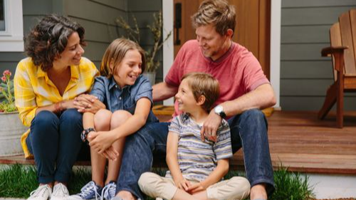 Image of family smiling, 2 adults and 2 kids