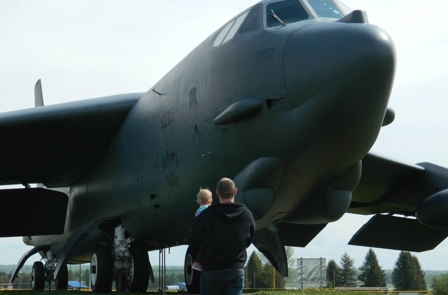 Dave holding his young daughter in his arms as they take in the sights of a static display of a B-52 in Rome, NY. 